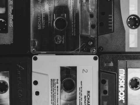 Image of black and white music cassettes, representing a collection of music recordings.