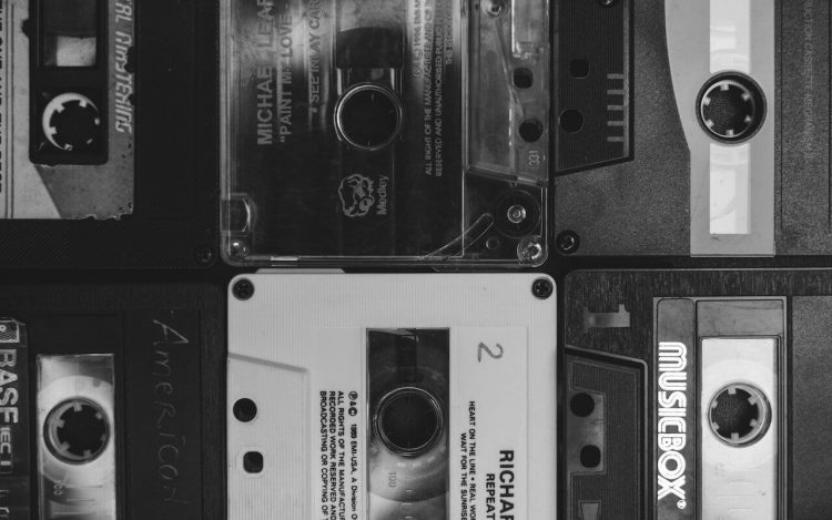 Image of black and white music cassettes, representing a collection of music recordings.